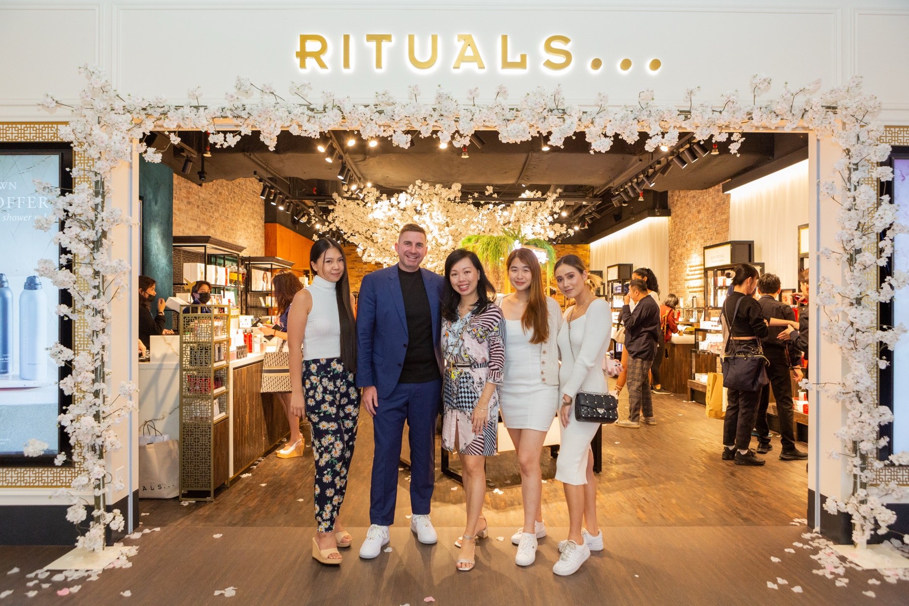 Rituals storefront on opening day, framed with cherry blossom, with the launch team at the entrance